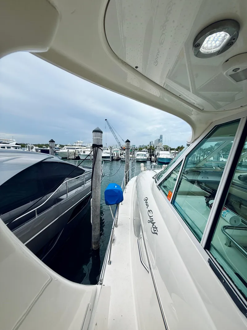 Slide: The Image of 2003 Sea Ray 480 Motor Yacht docked at marina, overcast sky, luxury boating scene. - 34