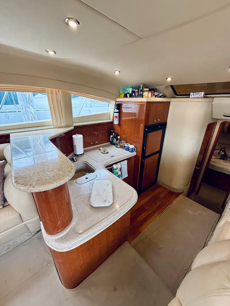 Slide: The Image of Luxurious 2003 Sea Ray 480 Motor Yacht interior with modern kitchen and elegant wood finishes. - 43