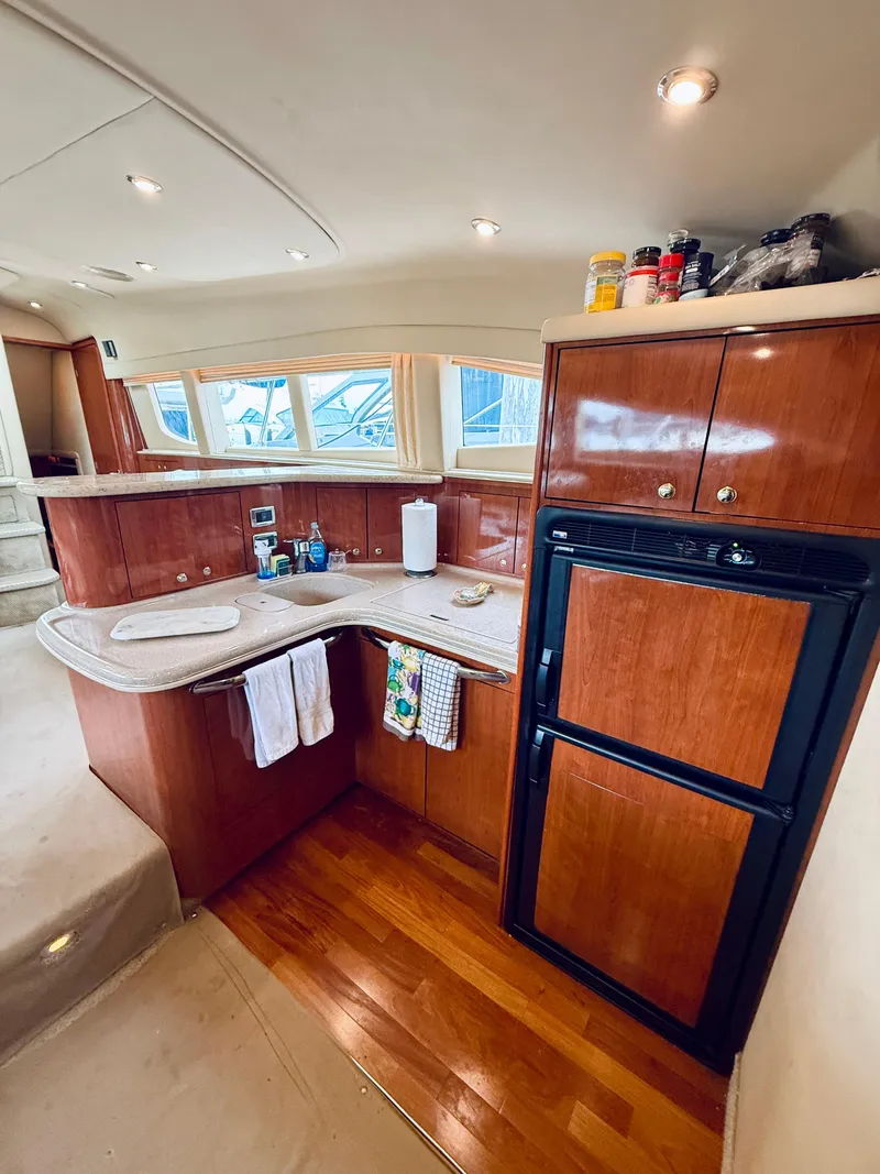 Slide: The Image of 2003 Sea Ray 480 Motor Yacht kitchen with wood cabinetry and modern appliances. - 45