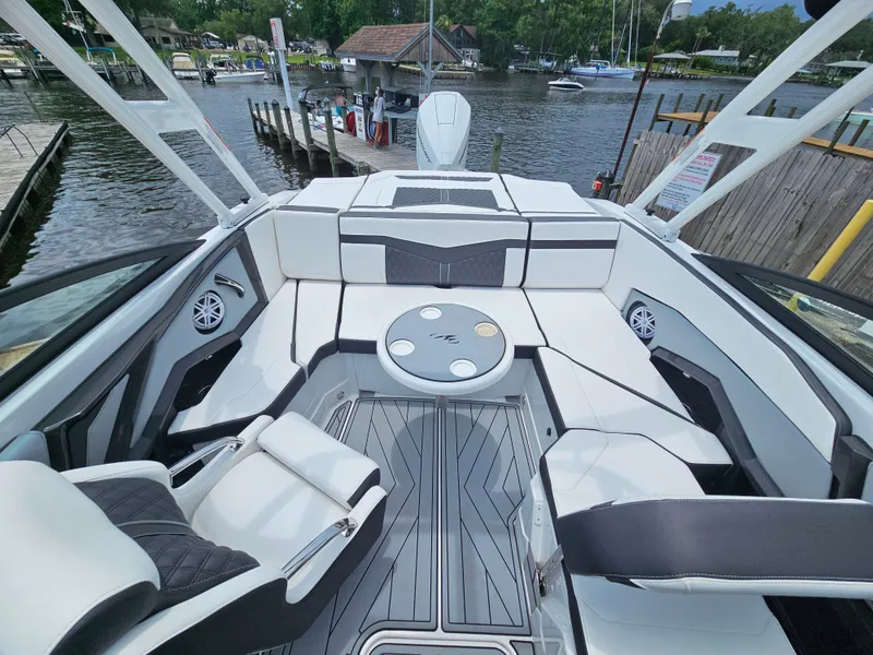 Slide: The Image of 2025 Monterey 235SS boat interior with sleek seating and modern design on a scenic waterfront. - 10