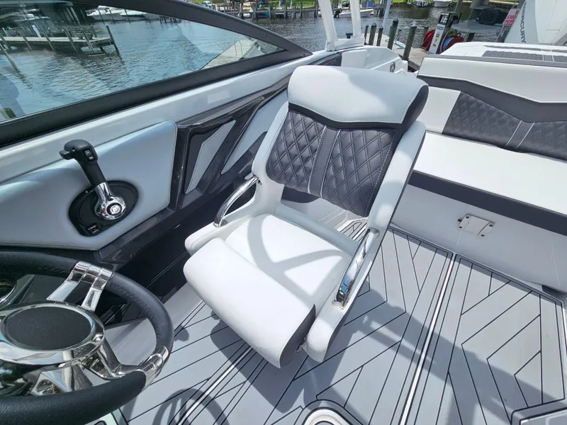 Slide: The Image of 2025 Monterey 235SS boat interior with sleek steering wheel and modern seating design. - 12