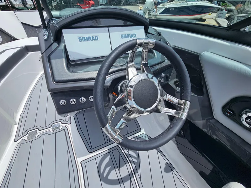 Slide: The Image of 2025 Monterey 235SS boat dashboard with dual Simrad displays and sleek steering wheel. - 13