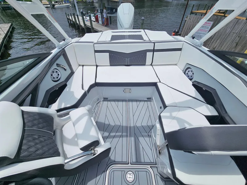 Slide: The Image of 2025 Monterey 235SS boat interior with sleek seating and modern design on a waterfront. - 26