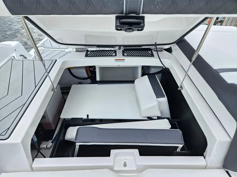 Slide: The Image of 2025 Monterey 235SS boat interior with open storage compartment and seating area. - 27