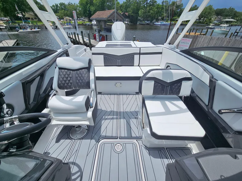 Slide: The Image of 2025 Monterey 235SS boat interior with sleek seating and modern design at a marina. - 9