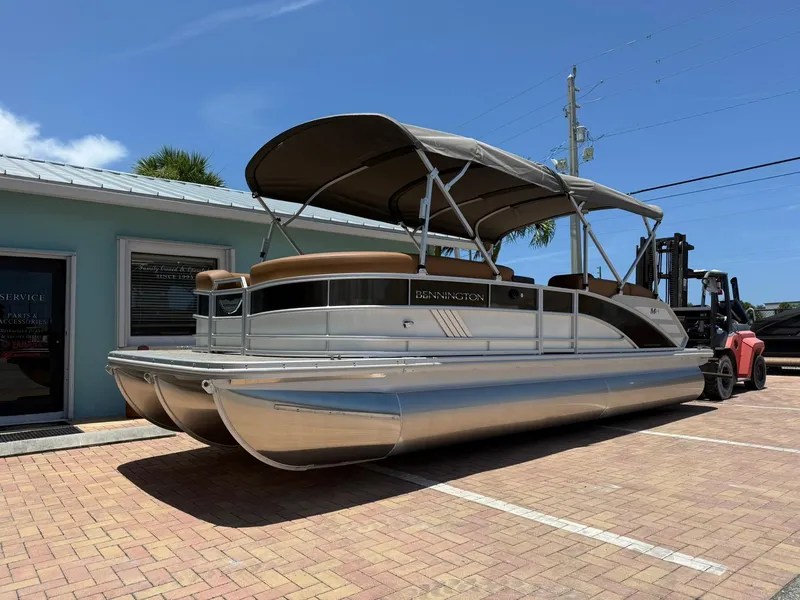 The Image of 2026 Bennington 24 MSB pontoon boat with canopy, parked on brick pavement. - 1