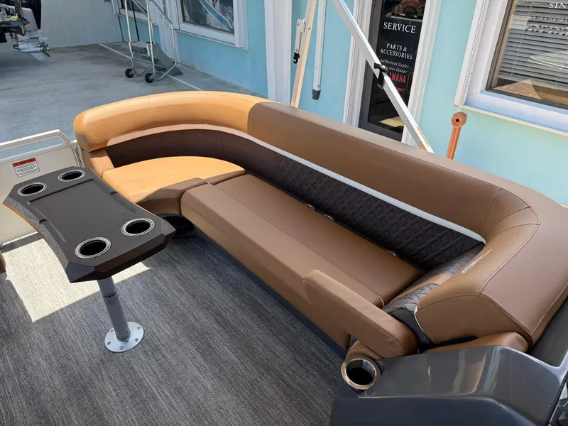 Slide: The Image of 2026 Bennington 24 MSB boat interior with brown seating and cupholder table. - 20