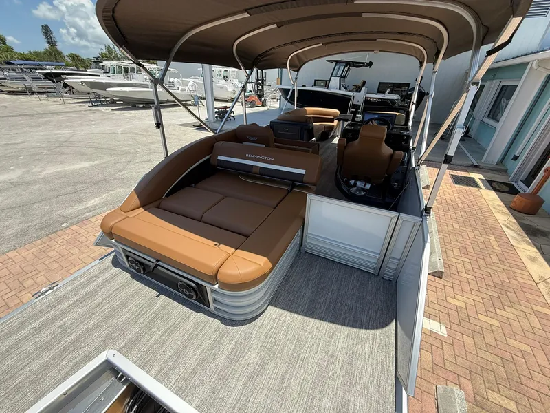 Slide: The Image of 2026 Bennington 24 MSB pontoon boat with tan seating and canopy, docked at marina. - 4