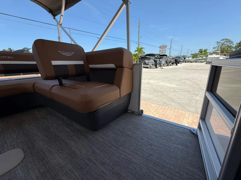 Slide: The Image of 2026 Bennington 24 MSB boat interior with brown seating and outdoor view. - 8