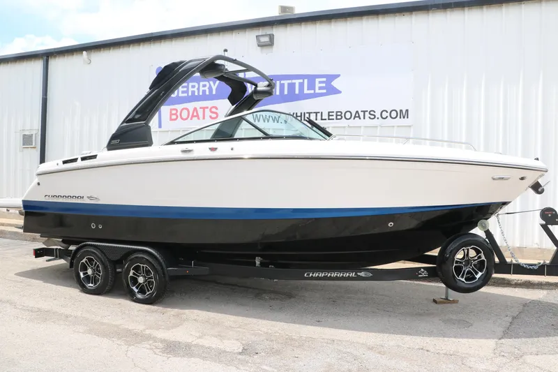 The Image of 2025 Chaparral 267 SSX boat on trailer, parked outside a building. - 0