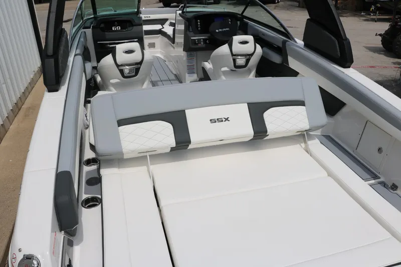Slide: The Image of 2025 Chaparral 267 SSX boat interior with white seating and modern dashboard. - 12