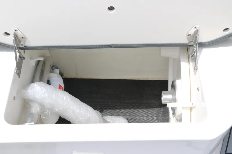 Slide: The Image of Storage compartment of 2025 Chaparral 267 SSX boat, featuring secure hinges and interior space. - 25