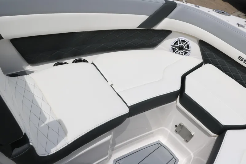 Slide: The Image of 2025 Chaparral 267 SSX boat interior with white and black seating and speaker. - 28