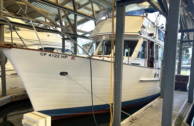 The Image of 1983 Island Gypsy 36 Quad Cabin boat docked in a marina. - 0