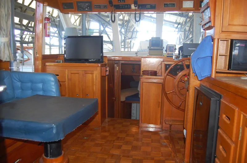 Slide: The Image of Interior of 1983 Island Gypsy 36 Quad Cabin with salon w/ settee, galley to starboard, and lower helm station. - 1