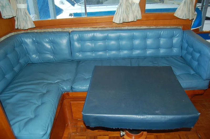 Slide: The Image of Blue leather seating area with table in 1983 Island Gypsy 36 Quad Cabin yacht interior. - 11