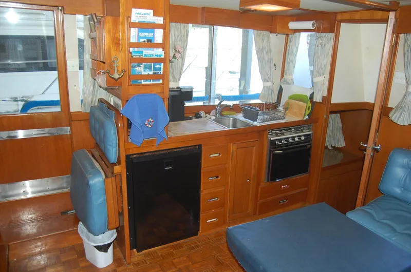 Slide: The Image of Interior of 1983 Island Gypsy 36 Quad Cabin with kitchen and seating area. - 14