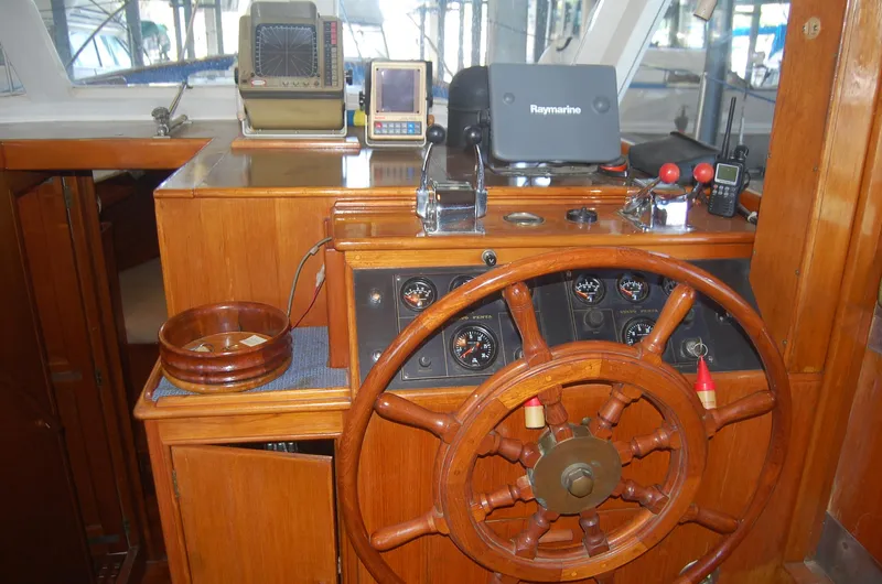 Slide: The Image of 1983 Island Gypsy 36 Quad Cabin helm with wooden wheel and navigation equipment. - 16