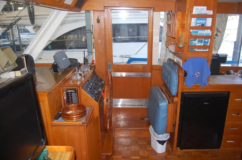 Slide: The Image of Interior of 1983 Island Gypsy 36 Quad Cabin with wooden finishes and navigation equipment. - 17