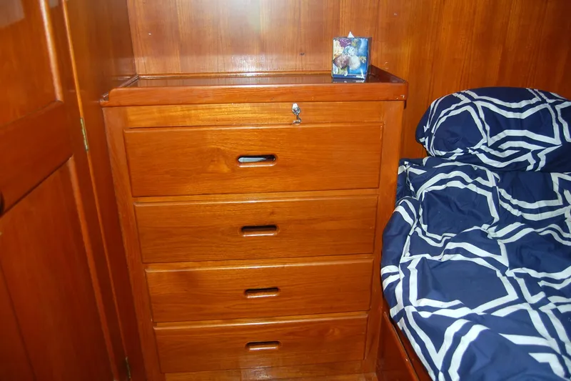 Slide: The Image of Wooden dresser and bed with geometric-patterned bedding in 1983 Island Gypsy 36 Quad Cabin. - 20