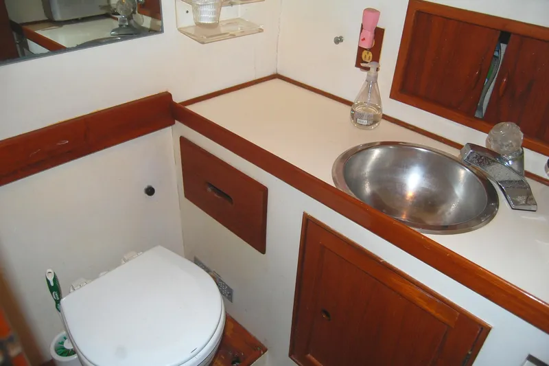 Slide: The Image of 1983 Island Gypsy 36 Quad Cabin bathroom with sink, toilet, and wooden cabinetry. - 22