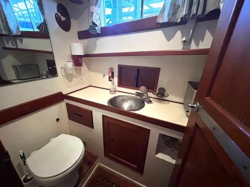 Slide: The Image of 1983 Island Gypsy 36 Quad Cabin bathroom with sink, toilet, and wooden accents. - 23