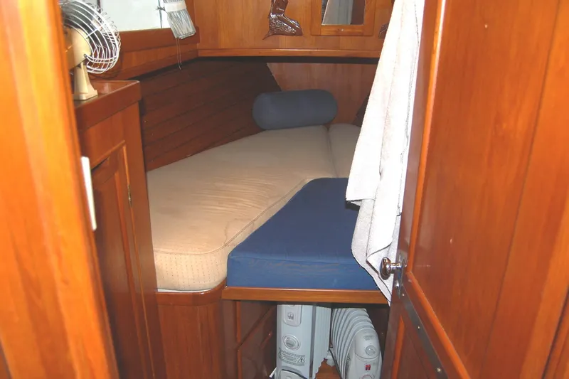 Slide: The Image of Cozy cabin interior of 1983 Island Gypsy 36 Quad, featuring wooden paneling and a comfortable bed. - 24