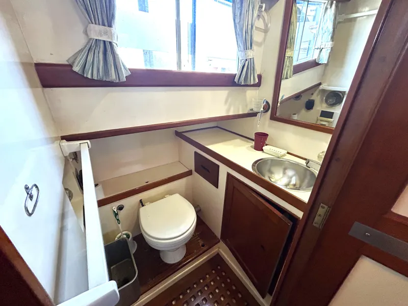 Slide: The Image of 1983 Island Gypsy 36 Quad Cabin bathroom with sink, toilet, and wooden accents. - 26