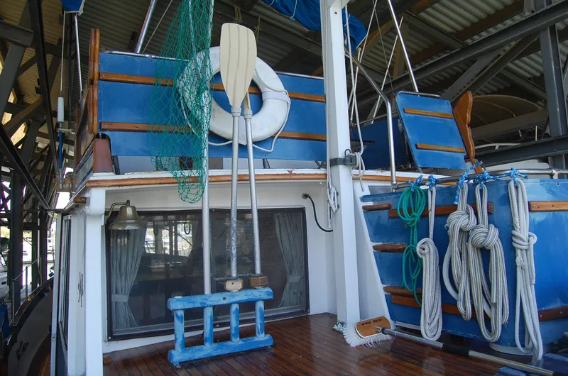 Slide: The Image of 1983 Island Gypsy 36 Quad Cabin boat deck with ropes, oars, and life preserver. - 30