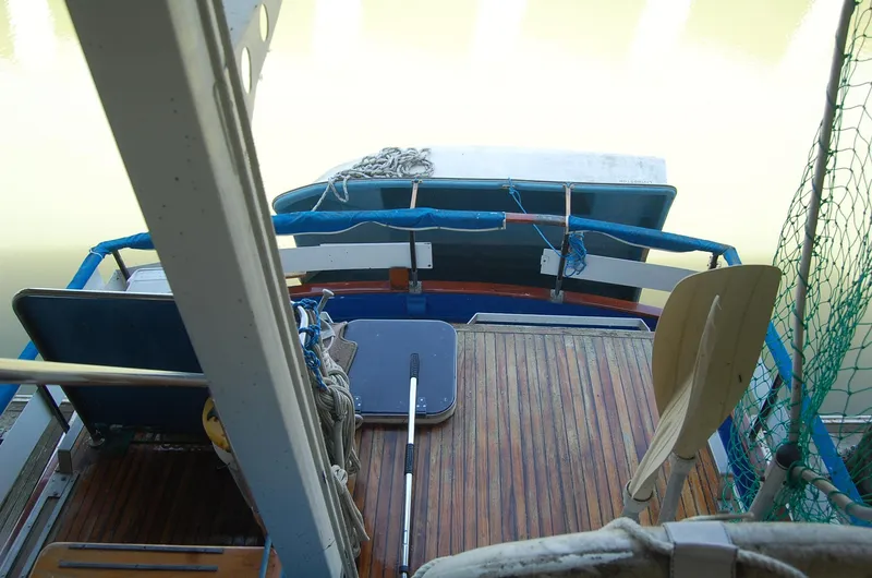 Slide: The Image of 1983 Island Gypsy 36 Quad Cabin boat deck with wooden flooring and seating. - 37