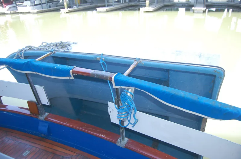 Slide: The Image of 1983 Island Gypsy 36 Quad Cabin boat detail with blue railing and dock background. - 38