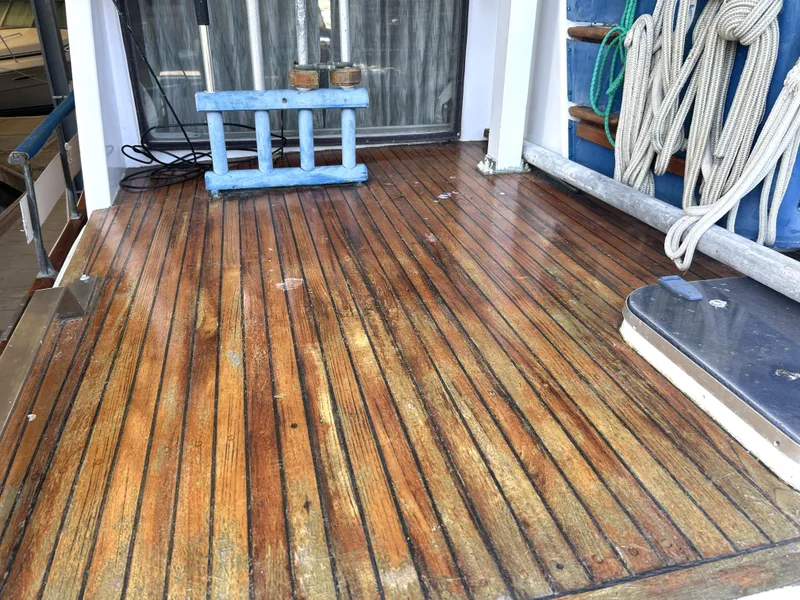 Slide: The Image of Teak deck of 1983 Island Gypsy 36 Quad Cabin with ropes and blue fender. - 39