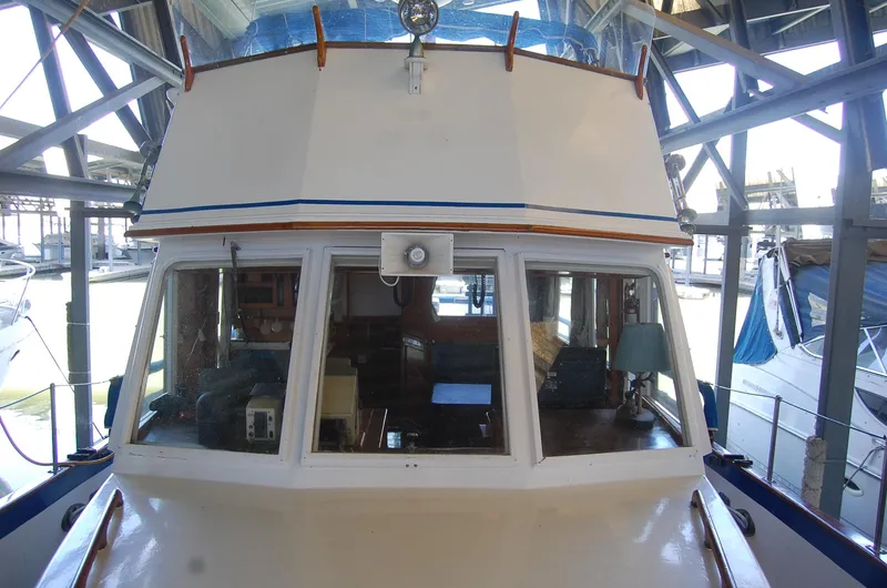 Slide: The Image of 1983 Island Gypsy 36 Quad Cabin boat docked in a marina, front view. - 40