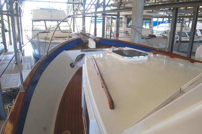 Slide: The Image of 1983 Island Gypsy 36 Quad Cabin yacht docked in a marina, showcasing deck and railing. - 41