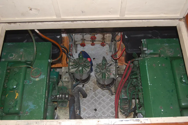 Slide: The Image of Engine compartment of 1983 Island Gypsy 36 Quad Cabin with visible green machinery and wiring. - 44