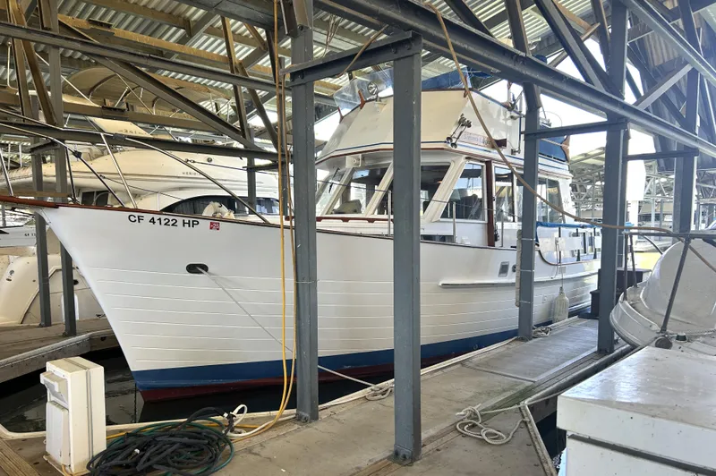 Slide: The Image of 1983 Island Gypsy 36 Quad Cabin docked in a marina under a metal roof. - 6