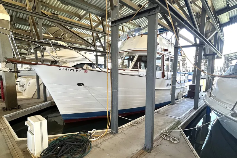 Slide: The Image of 1983 Island Gypsy 36 Quad Cabin docked in a covered marina. - 8