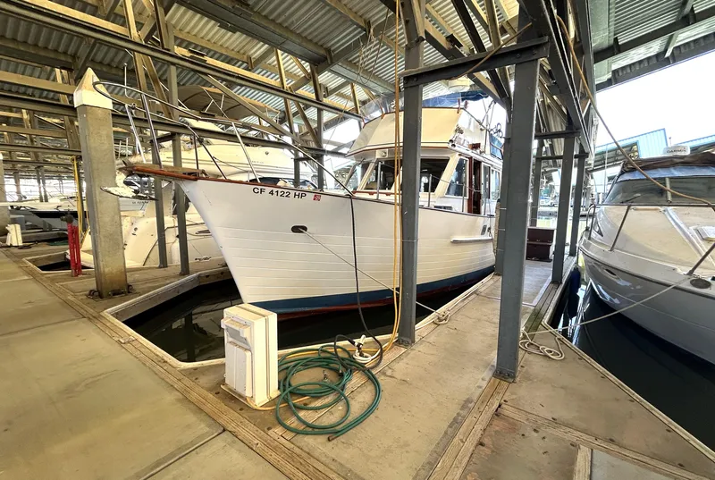 Slide: The Image of 1983 Island Gypsy 36 Quad Cabin docked in a covered marina. - 9