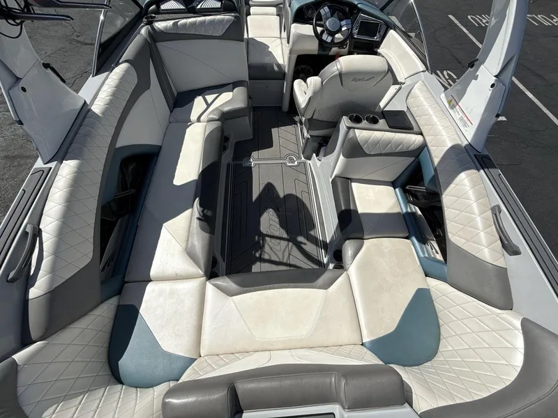 Slide: The Image of 2016 Tigé Z3 boat interior with white and gray seating, steering wheel, and cup holders. - 20