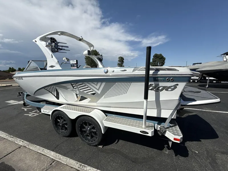 Slide: The Image of 2016 Tigé Z3 boat on trailer, sleek design, parked outdoors under a clear sky. - 3