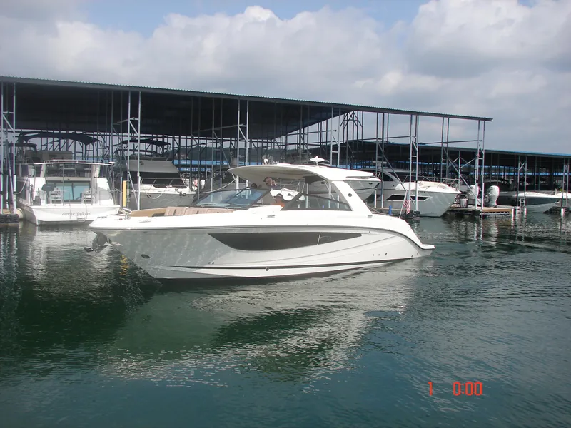 Slide: The Image of 2018 Sea Ray SLX 400 boat docked at marina under cloudy sky. - 14