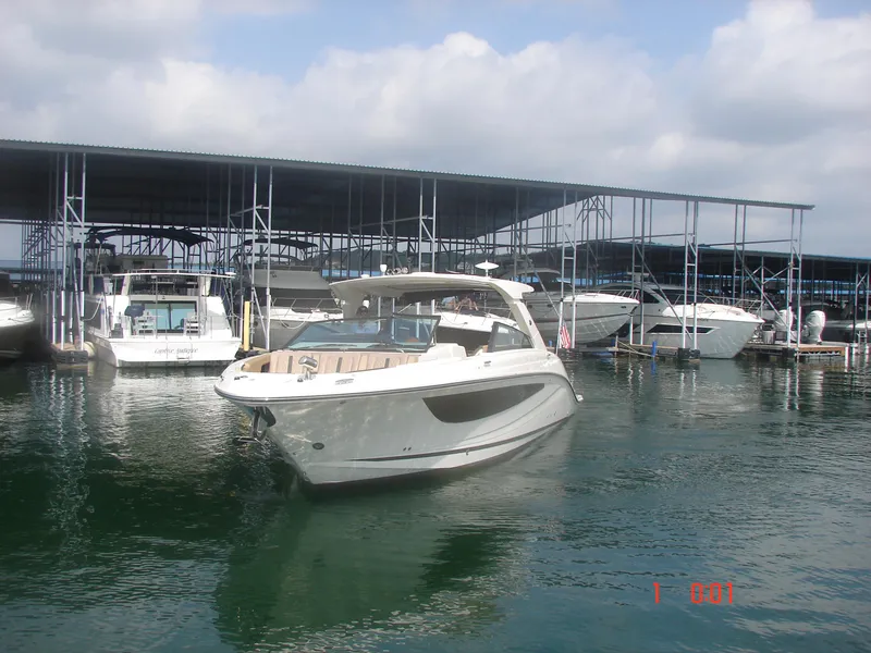 Slide: The Image of 2018 Sea Ray SLX 400 boat docked at marina under cloudy sky. - 16