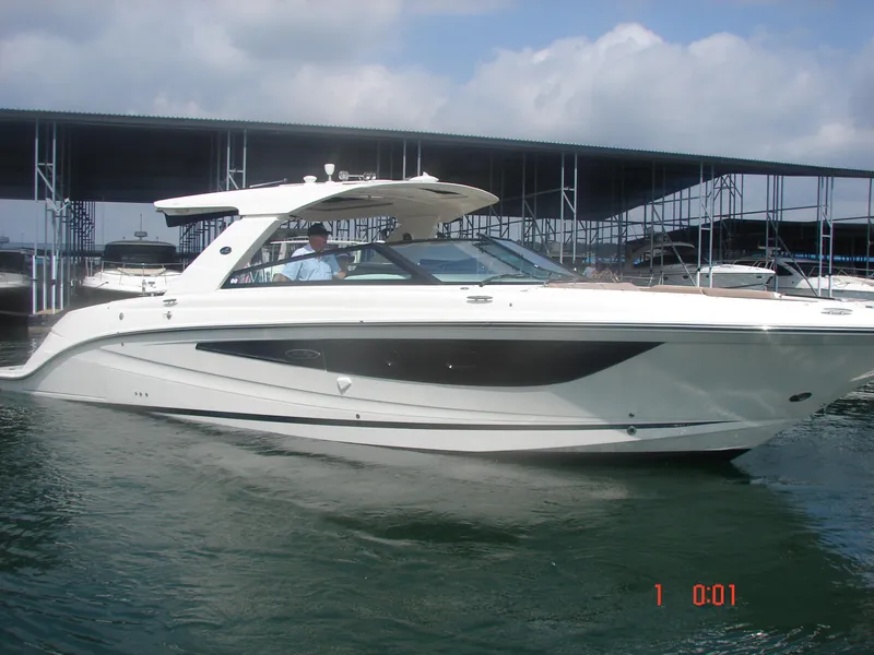 Slide: The Image of 2018 Sea Ray SLX 400 boat docked in a marina under a cloudy sky. - 21