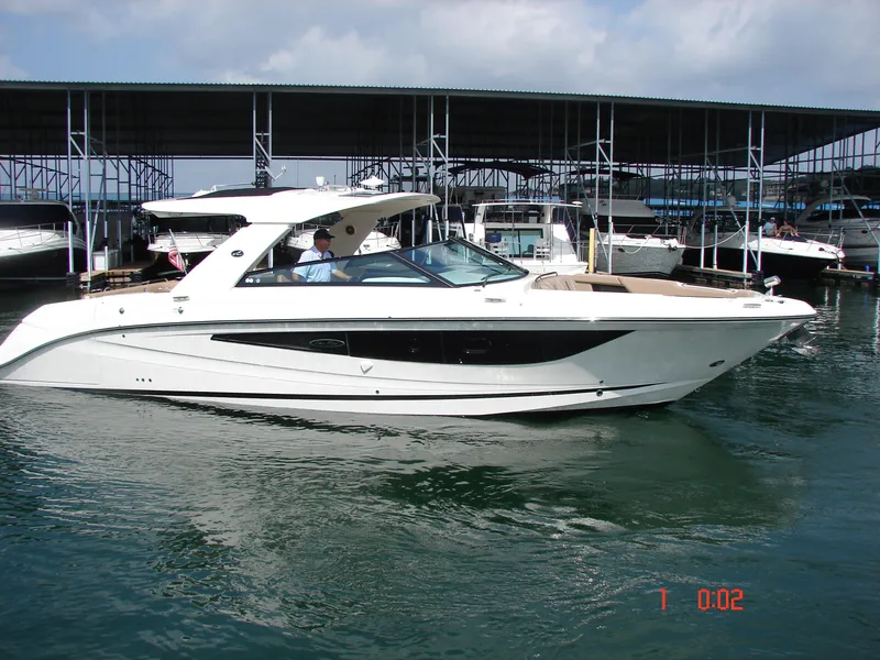 Slide: The Image of 2018 Sea Ray SLX 400 boat docked at marina under clear sky. - 25