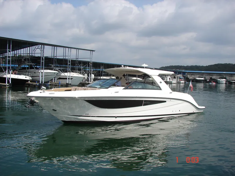 Slide: The Image of 2018 Sea Ray SLX 400 boat docked in a marina, calm water, cloudy sky. - 36