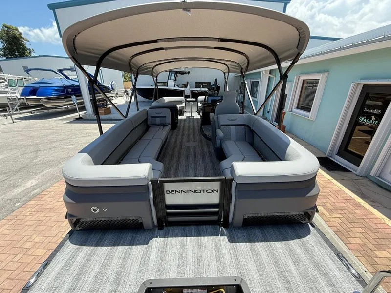 Slide: The Image of 2026 Bennington 26 MFB pontoon boat with spacious seating and canopy, displayed outdoors. - 3