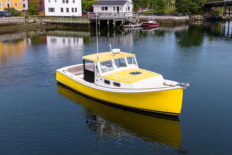 Slide: The Image of Yellow 2008 Holland Open boat on calm water near dockside buildings. - 10