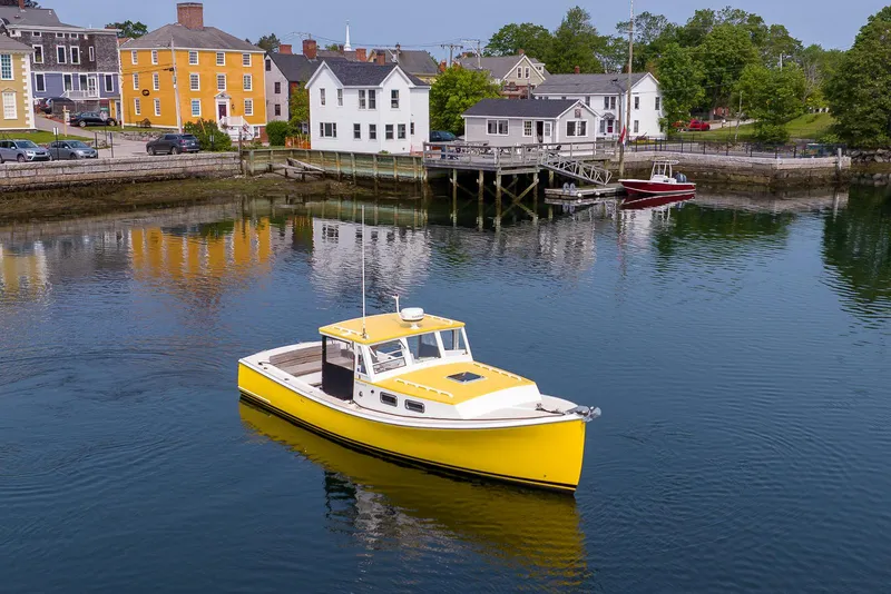 Slide: The Image of Yellow 2008 Holland Open boat on calm water near colorful waterfront buildings. - 11