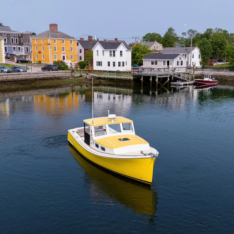 Slide: The Image of Yellow Holland Open boat on calm water near colorful waterfront buildings, 2008 model. - 12