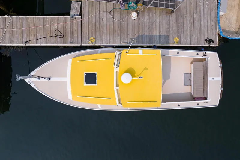 Slide: The Image of Aerial view of a 2008 Holland Open boat with a yellow roof docked at a wooden pier. - 13